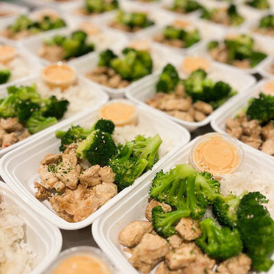 Zesty bang bang chicken with broccoli and rice, spicy sauce on the side.