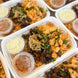 A spicy chipotle chicken bowl with beans, rice and side sauces in a takeout container.